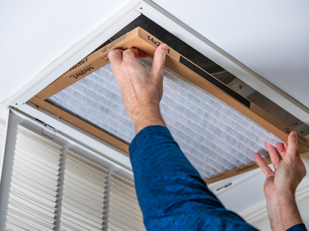 HVAC technician replacing a home air filter in Covina