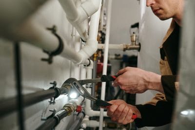 Technician inspecting commercial plumbing pipes in Covina
