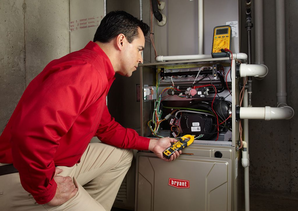 Heating technician diagnosing a furnace repair in Covina
