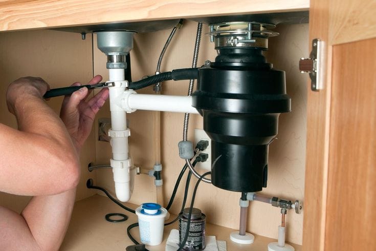 Plumber repairing a garbage disposal in Covina