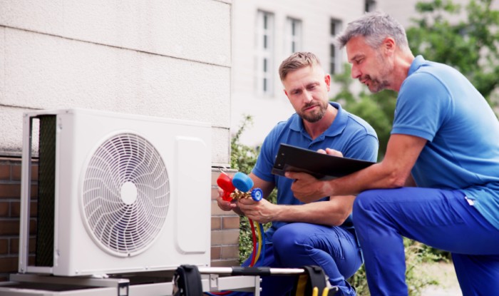 HVAC technicians installing an outdoor air conditioning unit in Covina