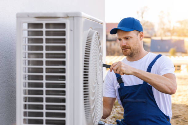 HVAC technician servicing an outdoor air conditioner in Covina