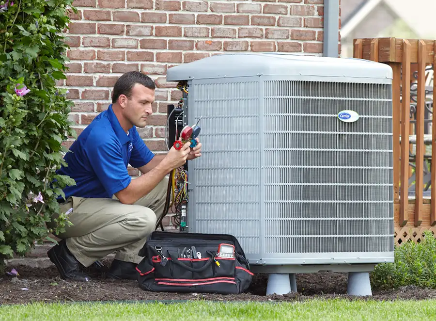HVAC technician inspecting an outdoor AC unit in Covina